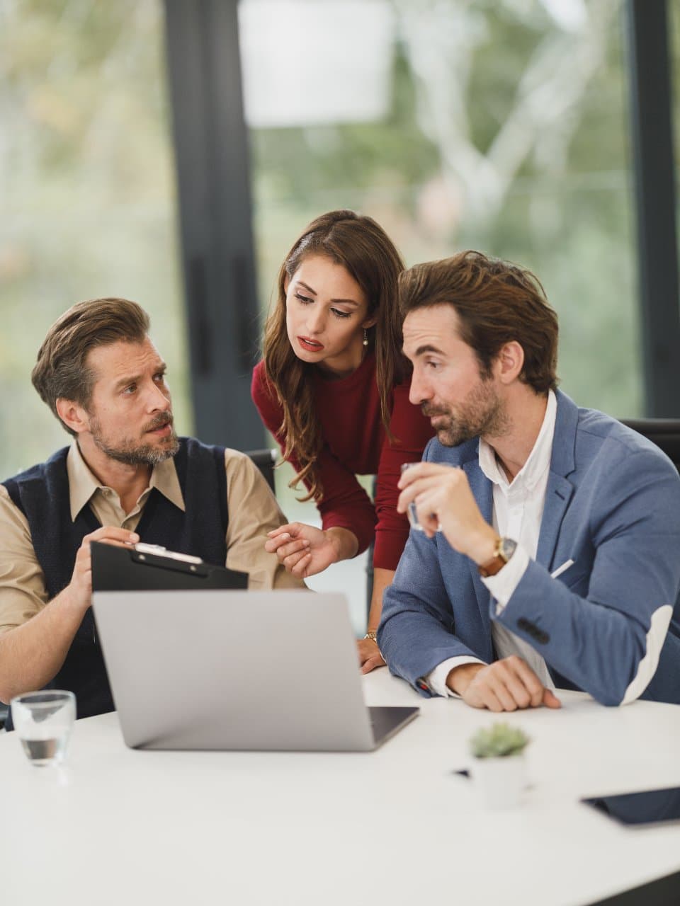 Three colleagues going through a report together on a laptop