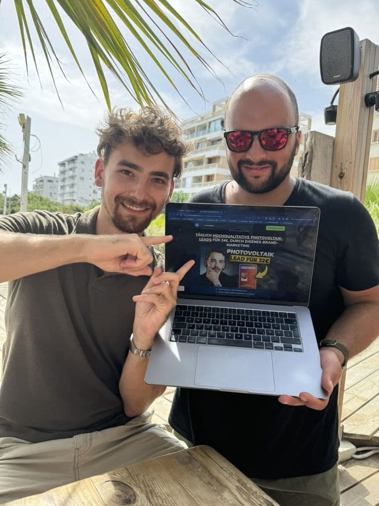 Two team members in Cyprus showing the LeadJourney dashboard on a laptop