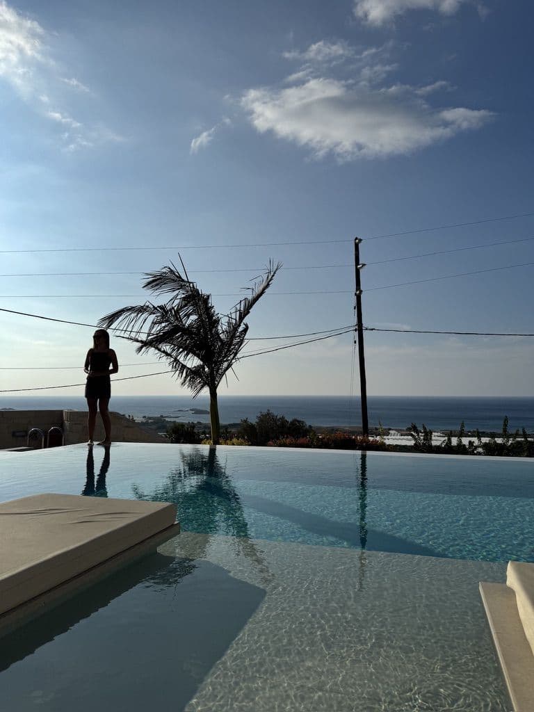 Infinity pool at the workation villa with the sea behind it
